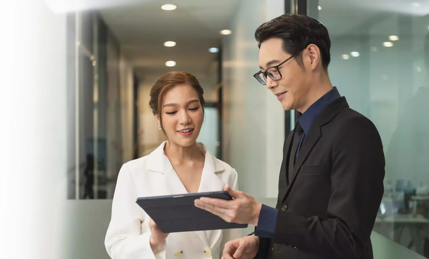smiling-asian-businesswoman-showing-tablet-her-manager-during-meeting-office_730_fr (1)